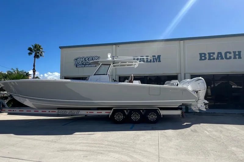 The Image of 2025 Jupiter 380LS boat docked at marina with clear skies and palm trees. - 0