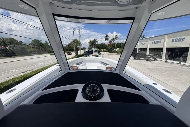 Slide: The Image of 2025 Jupiter 380 LS boat roof with rod holders and speakers under a clear sky. - 10
