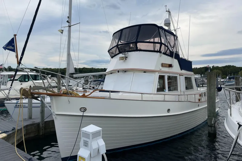 Slide: The Image of 1990 Grand Banks 42 Classic yacht docked at marina, featuring classic design and spacious deck. - 11