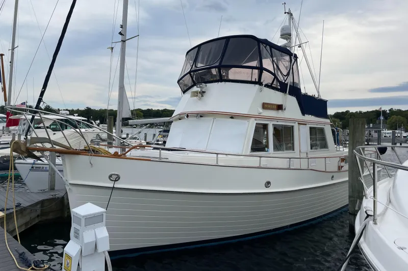 Slide: The Image of 1990 Grand Banks 42 Classic yacht docked at a marina under cloudy skies. - 12