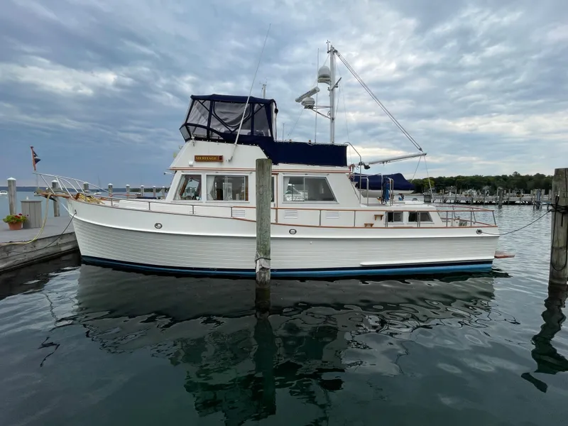 Slide: The Image of 1990 Grand Banks 42 Classic yacht docked at a marina under cloudy skies. - 15