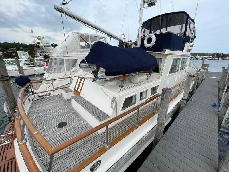 Slide: The Image of 1990 Grand Banks 42 Classic yacht docked, showcasing elegant wooden deck and nautical features. - 16