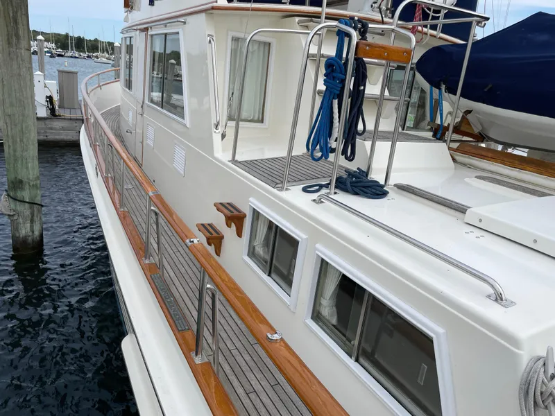 Slide: The Image of 1990 Grand Banks 42 Classic yacht docked, showcasing teak deck and polished railings. - 18