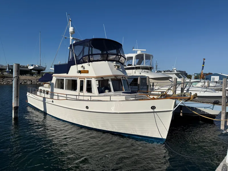 Slide: The Image of 1990 Grand Banks 42 Classic yacht docked at marina under clear blue sky. - 2