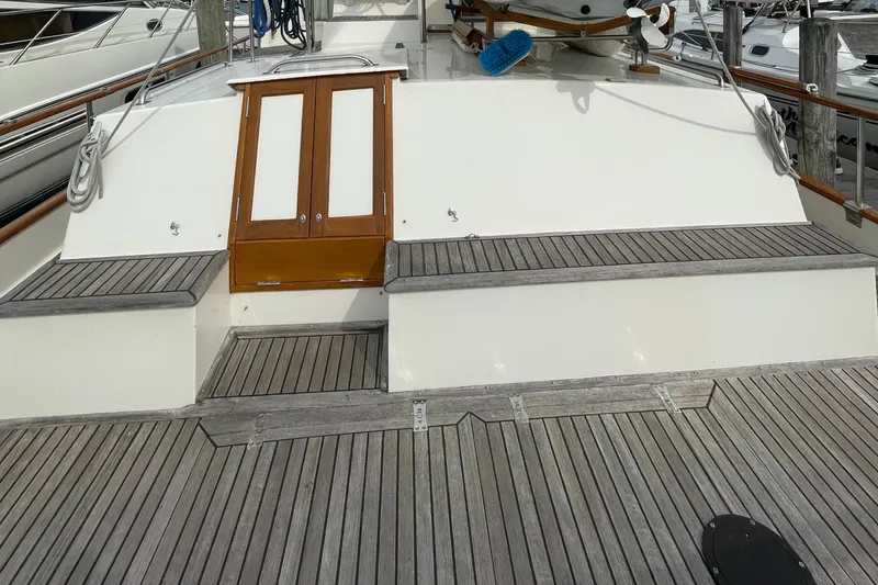 Slide: The Image of 1990 Grand Banks 42 Classic yacht deck with wooden seating and storage compartments. - 27