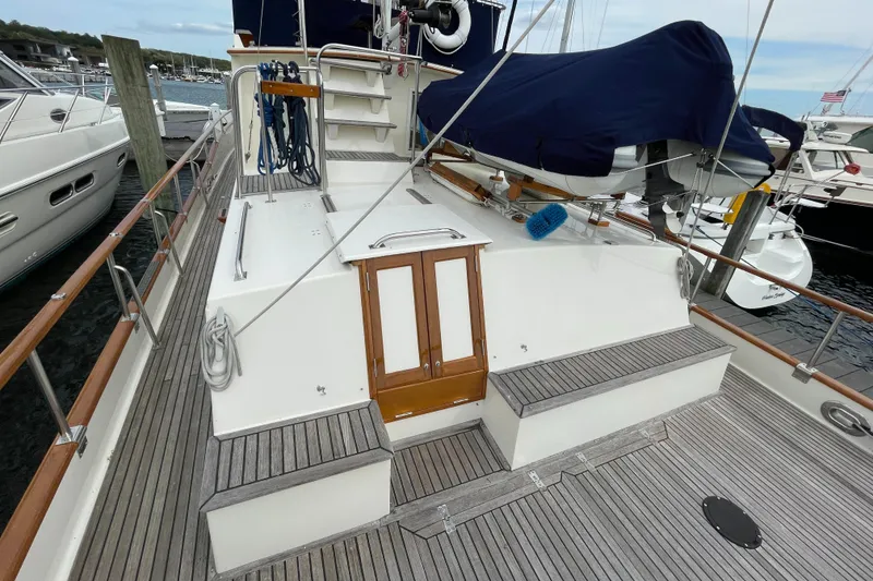 Slide: The Image of 1990 Grand Banks 42 Classic yacht deck with wooden accents and covered equipment. - 29