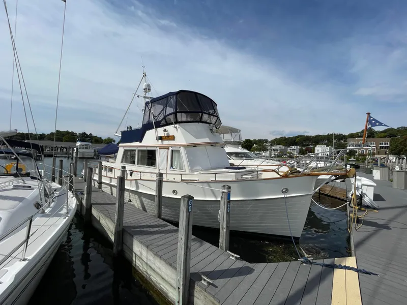 Slide: The Image of 1990 Grand Banks 42 Classic yacht docked at a marina under a clear sky. - 3