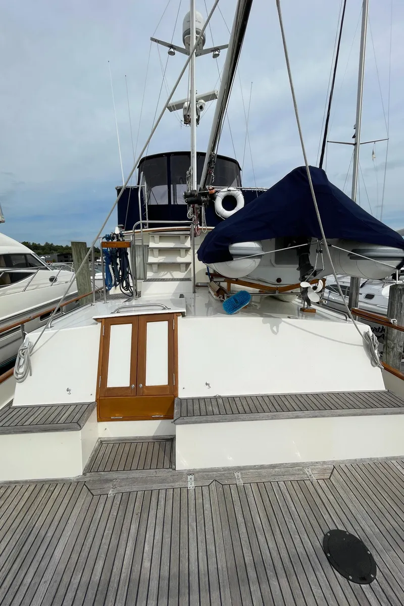 Slide: The Image of 1990 Grand Banks 42 Classic yacht with wooden deck and covered dinghy at marina. - 31