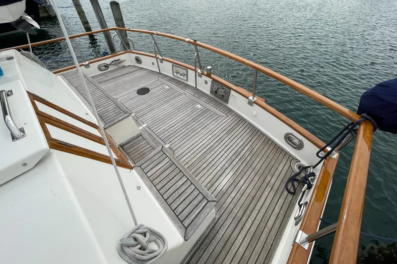 Slide: The Image of 1990 Grand Banks 42 Classic yacht deck with wooden railings and ocean view. - 34