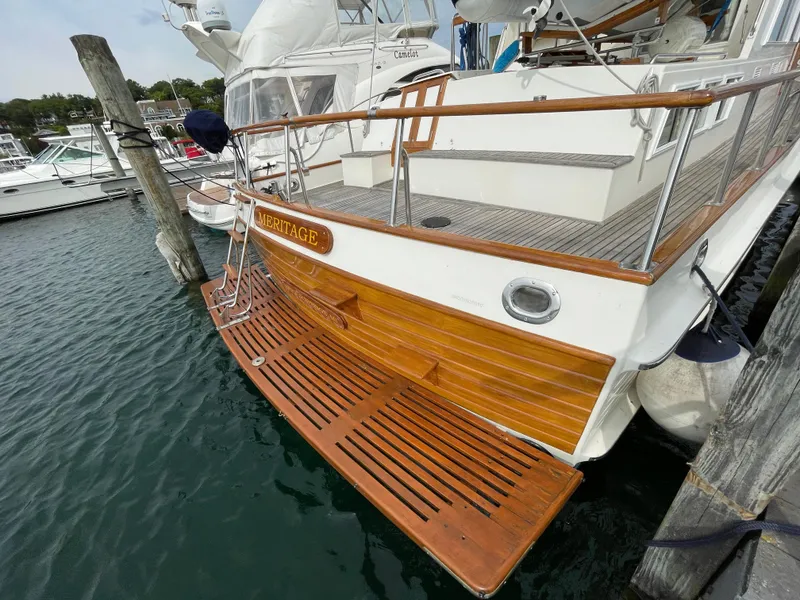 Slide: The Image of 1990 Grand Banks 42 Classic yacht docked, featuring wooden deck and swim platform. - 36