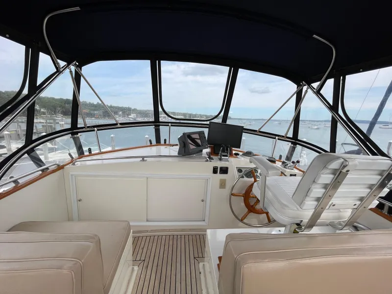 Slide: The Image of Flybridge of 1990 Grand Banks 42 Classic yacht with helm station and seating, overlooking marina. - 45