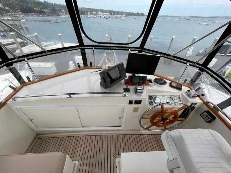 Slide: The Image of Helm of 1990 Grand Banks 42 Classic yacht with wooden wheel and navigation equipment. - 46