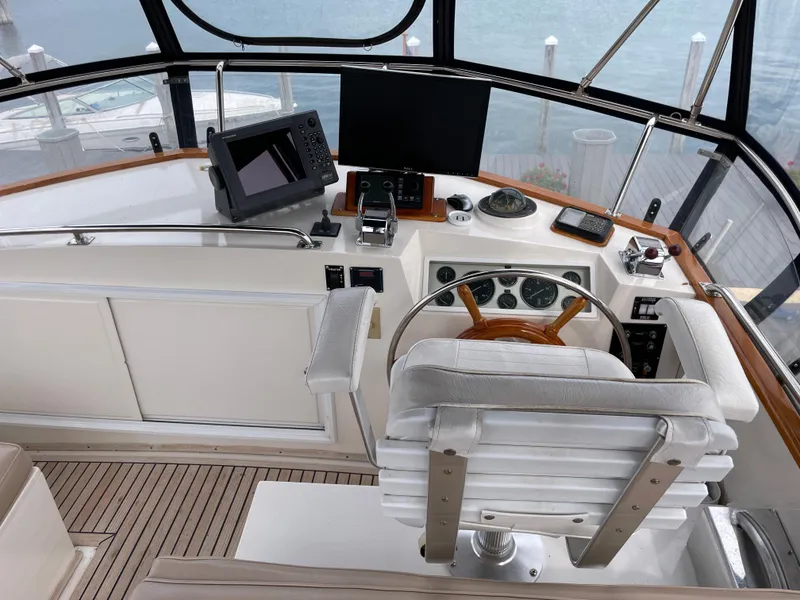 Slide: The Image of Helm of 1990 Grand Banks 42 Classic yacht with navigation equipment and wooden steering wheel. - 47