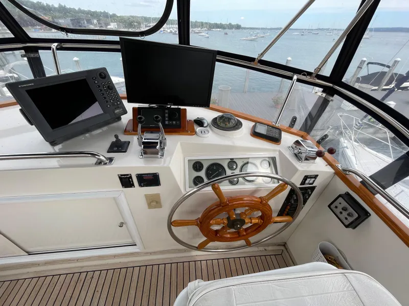 Slide: The Image of Helm of 1990 Grand Banks 42 Classic yacht with navigation equipment and wooden steering wheel. - 49