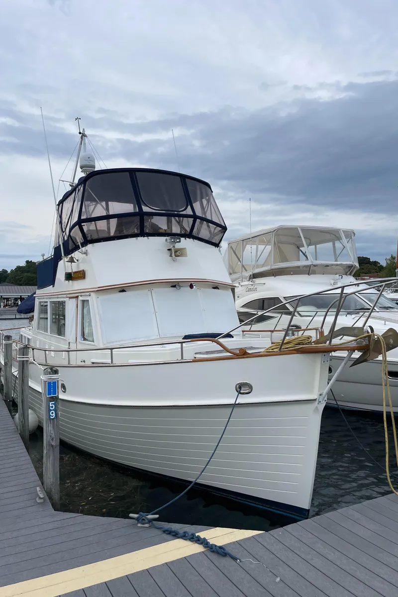 Slide: The Image of 1990 Grand Banks 42 Classic yacht docked at marina under cloudy sky. - 6