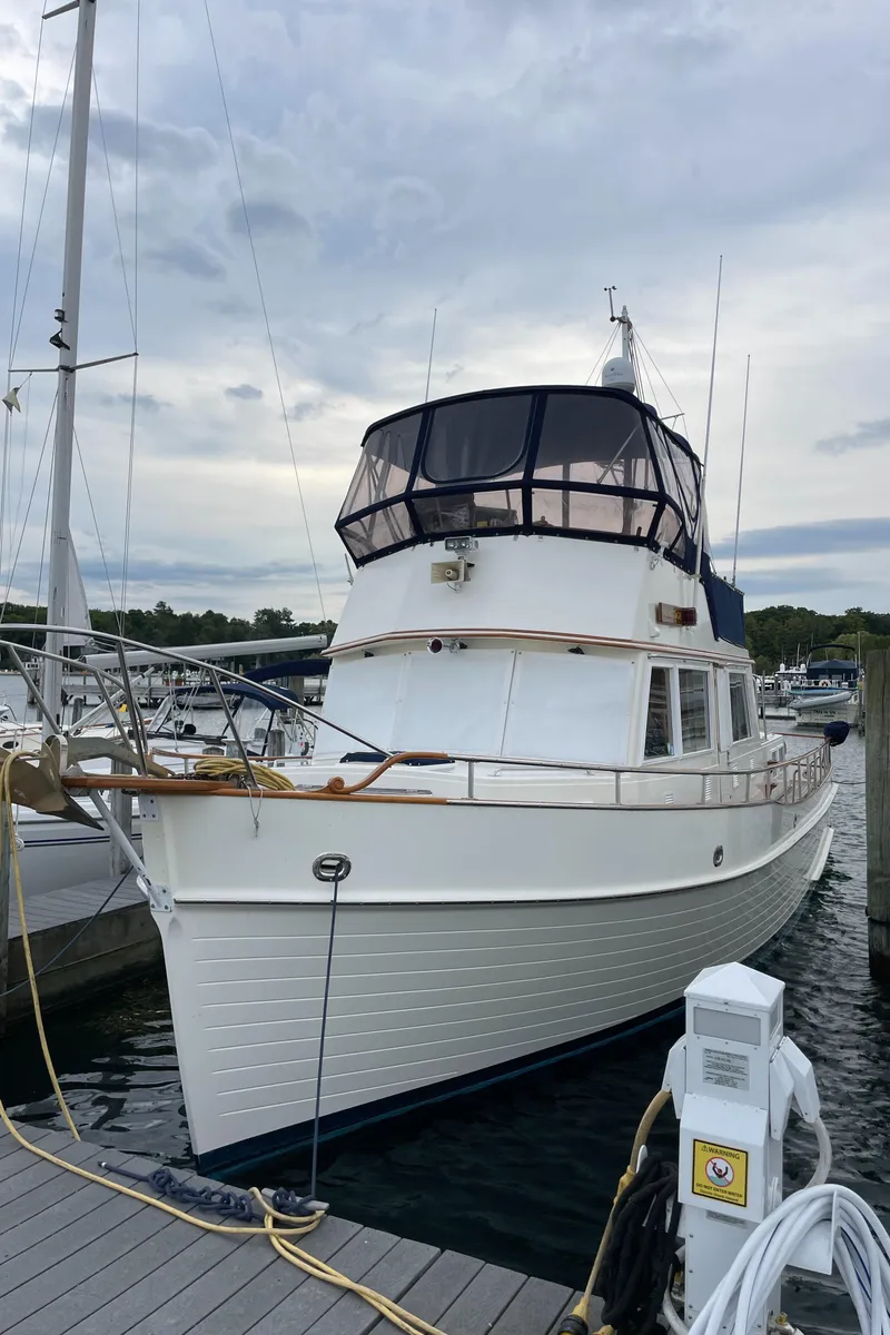 Slide: The Image of Grand Banks 42 Classic 1990 yacht docked at marina under cloudy sky. - 7