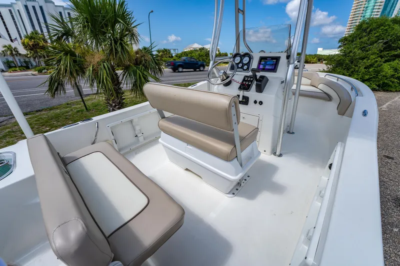 Slide: The Image of 2017 NauticStar 19XS boat interior with beige seating and modern dashboard controls. - 11