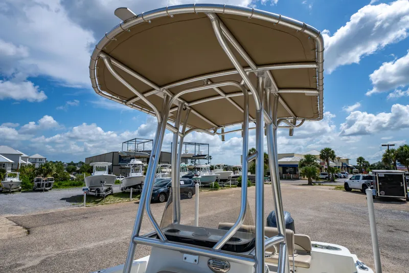 Slide: The Image of 2017 NauticStar 19XS boat with T-top, parked outdoors under a blue sky. - 18