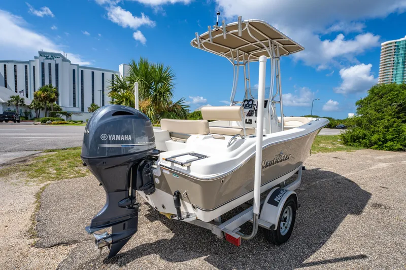 Slide: The Image of 2017 NauticStar 19XS boat with Yamaha engine, parked near a hotel under a blue sky. - 3