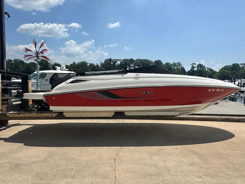 The Image of 2014 Sea Ray 240 Sundeck boat on a lift, red and white design, sunny day. - 0
