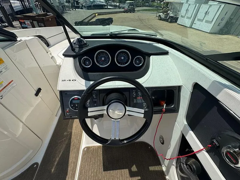 Slide: The Image of 2014 Sea Ray 240 Sundeck dashboard with steering wheel and instrument panel. - 11