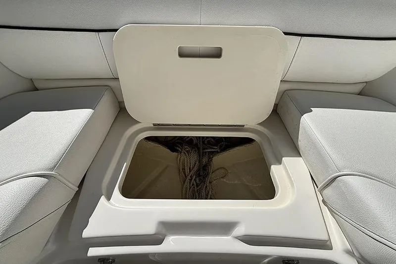 Slide: The Image of 2014 Sea Ray 240 Sundeck storage compartment with open hatch, revealing interior ropes. - 23