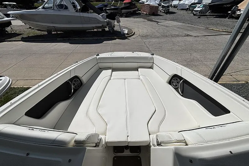 Slide: The Image of 2014 Sea Ray 240 Sundeck boat interior with white seating and speakers. - 25