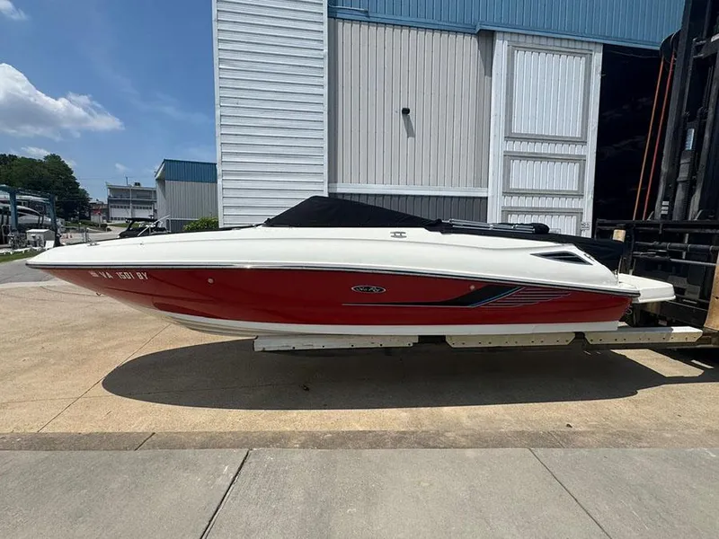Slide: The Image of 2014 Sea Ray 240 Sundeck boat with red hull, docked outdoors. - 3