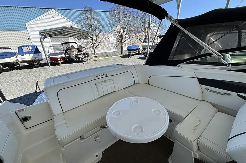 Slide: The Image of 2014 Sea Ray 240 Sundeck boat interior with white seating and round table. - 30