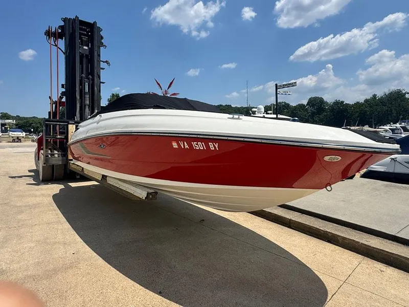 Slide: The Image of 2014 Sea Ray 240 Sundeck boat on forklift, red and white hull, sunny day. - 4