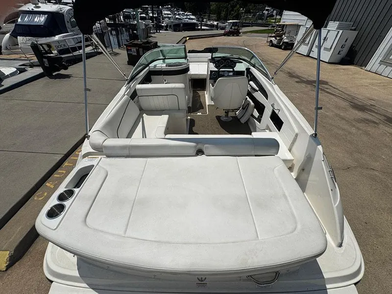 Slide: The Image of 2014 Sea Ray 240 Sundeck boat interior with seating and helm, docked at marina. - 6