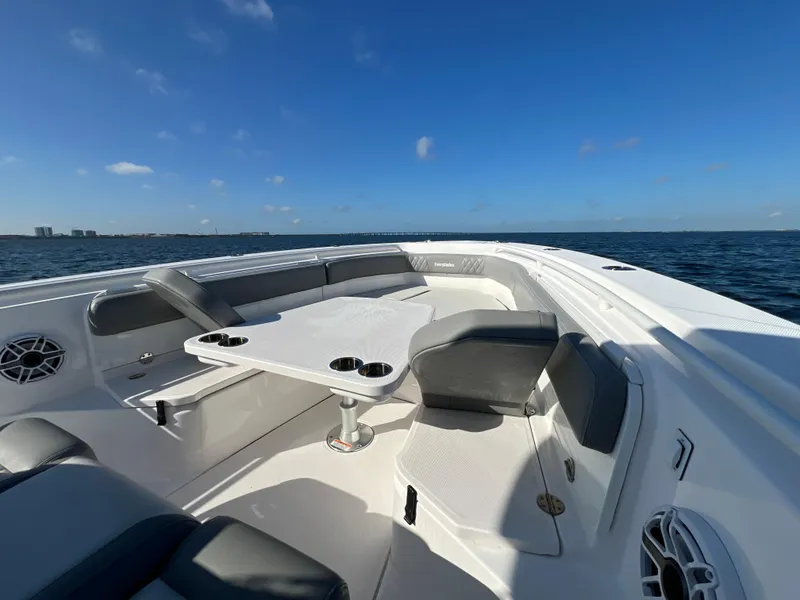 Slide: The Image of 2023 Everglades 365 Center Console boat interior with seating and table on open water. - 11