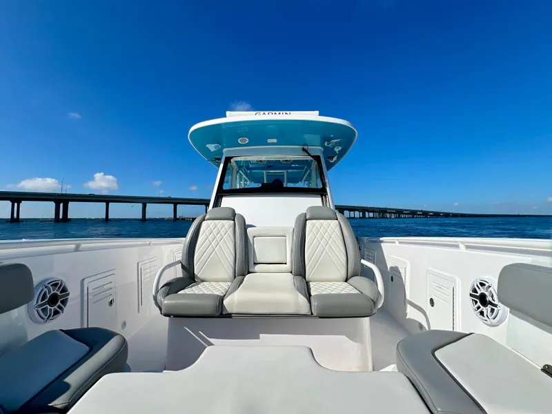 Slide: The Image of 2023 Everglades 365 Center Console boat on water, clear sky, bridge in background. - 14