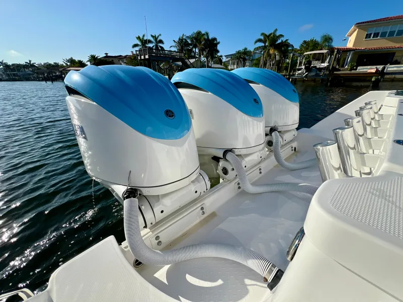 Slide: The Image of 2023 Everglades 365 Center Console with triple outboard engines on a sunny waterfront. - 23