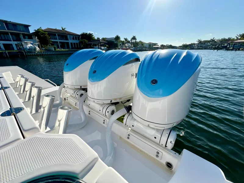 Slide: The Image of 2023 Everglades 365 Center Console boat with triple outboard engines on a sunny day. - 24