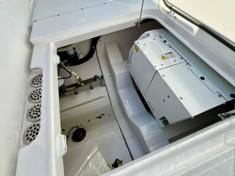 Slide: The Image of 2023 Everglades 365 Center Console boat engine compartment with visible machinery and components. - 26