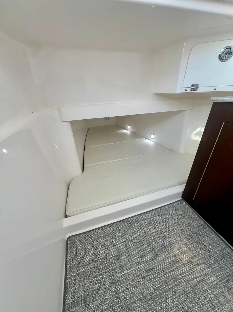 Slide: The Image of Interior cabin of 2023 Everglades 365 Center Console boat, featuring cushioned seating and storage. - 28