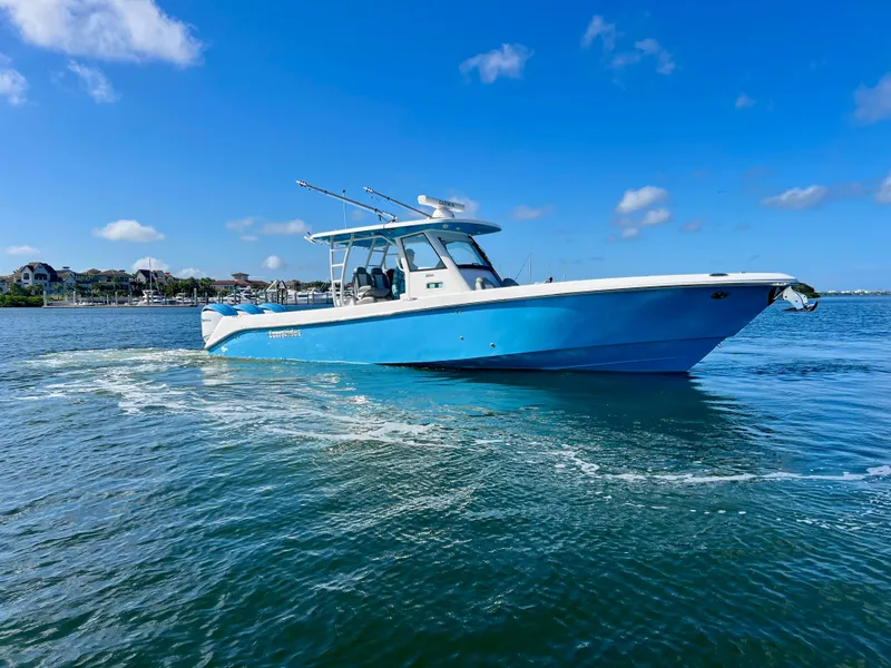 Slide: The Image of 2023 Everglades 365 Center Console boat cruising on clear blue water under a sunny sky. - 29