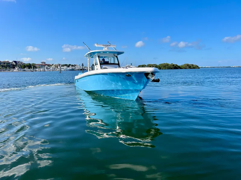 Slide: The Image of 2023 Everglades 365 Center Console boat on calm water under clear blue sky. - 34