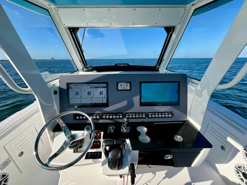 Slide: The Image of 2023 Everglades 365 Center Console boat dashboard with navigation screens and steering wheel. - 4