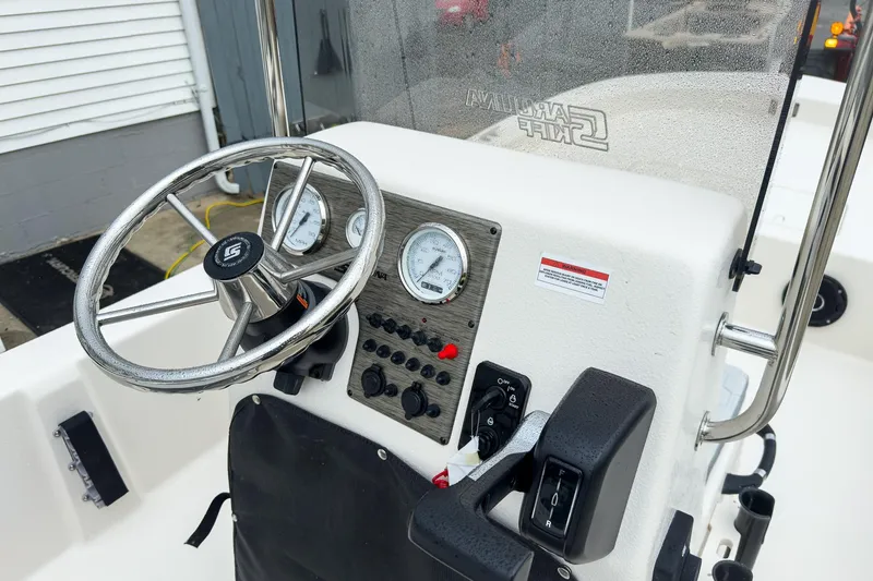 Slide: The Image of 2026 Carolina Skiff E20 JVX CC boat console with steering wheel and gauges. - 13