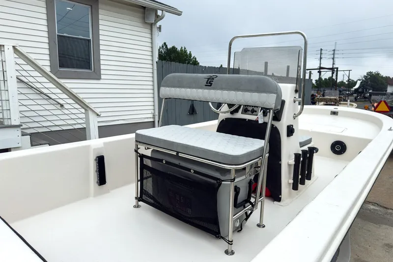Slide: The Image of 2026 Carolina Skiff E20 JVX CC boat with center console and seating, docked near a house. - 16
