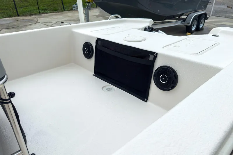 Slide: The Image of 2026 Carolina Skiff E20 JVX CC boat interior with speakers and storage compartments. - 17