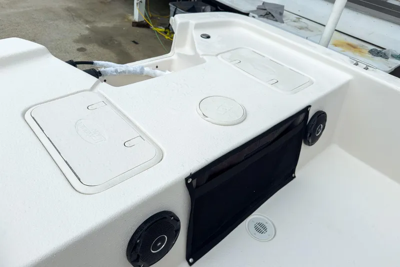 Slide: The Image of 2026 Carolina Skiff E20 JVX CC boat interior with storage compartments and speakers. - 18