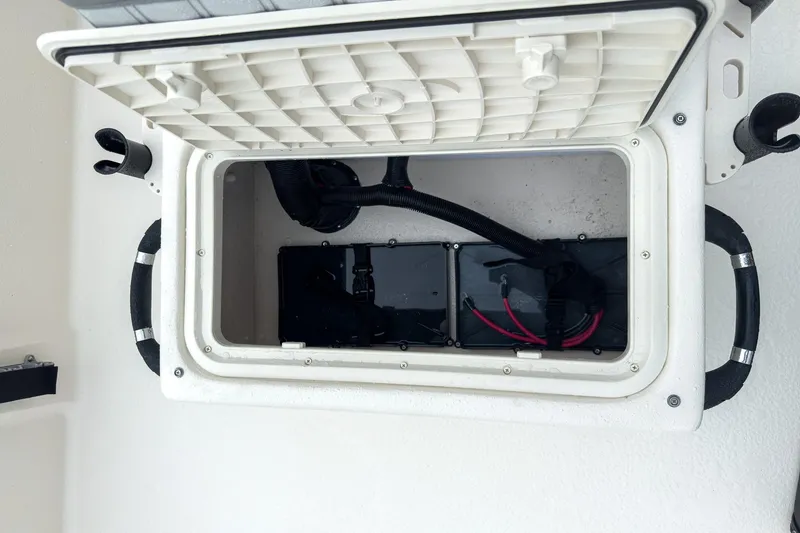 Slide: The Image of Open battery compartment of 2026 Carolina Skiff E20 JVX CC boat. - 23