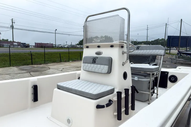 Slide: The Image of 2026 Carolina Skiff E20 JVX CC boat interior with seating and console, parked outdoors. - 5