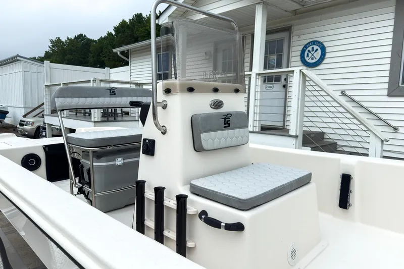 Slide: The Image of 2026 Carolina Skiff E20 JVX CC boat interior with seating and console, docked near a building. - 6