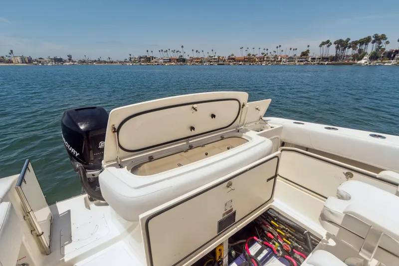 Slide: The Image of 2008 Fountain 38 Sport Cruiser boat with open storage, docked near a scenic waterfront. - 5