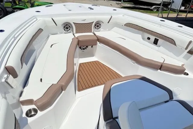 Slide: The Image of 2025 Tidewater 272 CC Adventure boat interior with cushioned seating and teak flooring. - 15