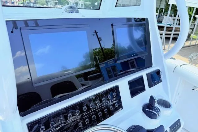 Slide: The Image of 2025 Tidewater 272 CC Adventure boat dashboard with dual screens and controls. - 23